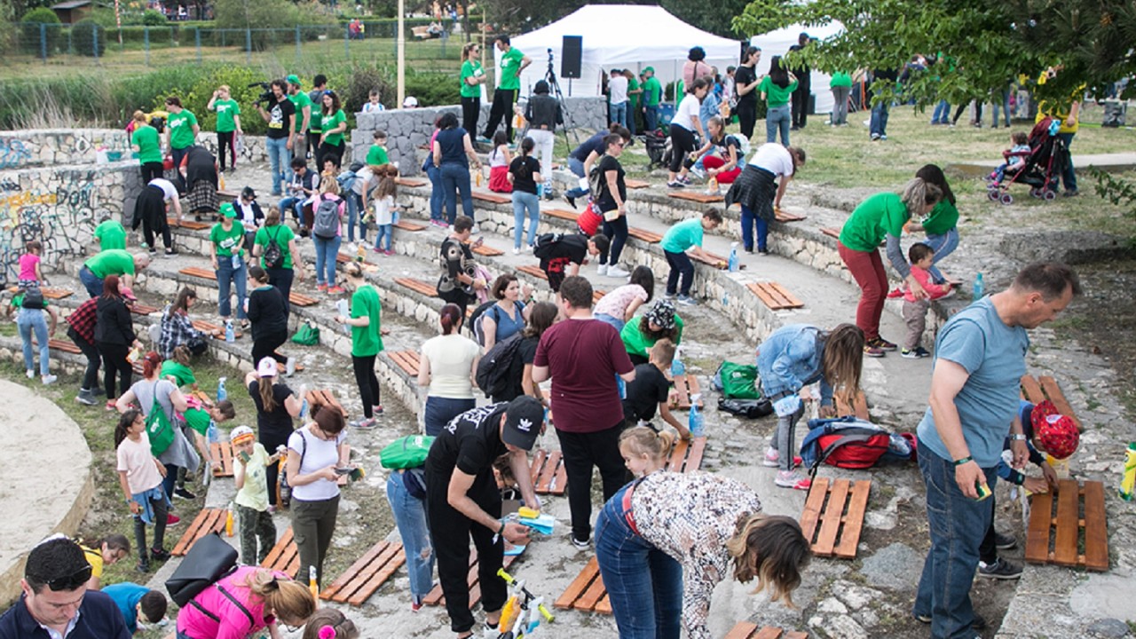 A group of children & adults cleaning up a street